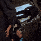 a person wearing a black nooo sweatshirt is laying on their back