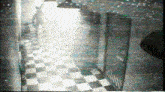a black and white photo of a hallway with checkered floors