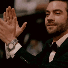 a man in a tuxedo with a watch on his wrist