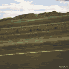 a gif of a car driving down a road with a yellow line