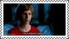 a young man in a red shirt is looking at the camera .