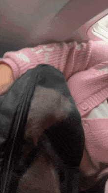 a person in a pink sweater is sitting in a chair