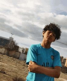 a young man wearing a blue shirt that says all on it
