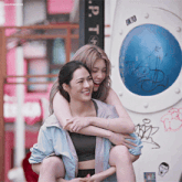 two women hugging each other in front of a sign that says uk10