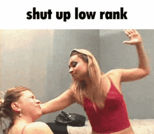a woman in a red tank top is slapping another woman in the face