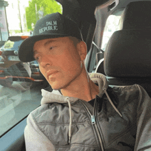 a man wearing a hat that says palm republic on it