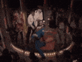 a group of people are dancing on a stage in front of a crowd .