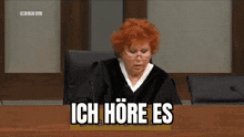 a woman in a judge 's robe is sitting at a desk with the words ich hre es written on it
