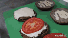 a bunch of hamburgers with tomatoes and cheese on a green cutting board made in animatica