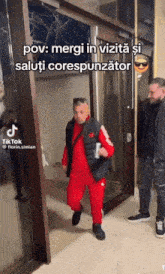 a man in a red suit is walking through a glass door with a caption that says pov mergi in vizita