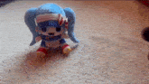 a stuffed doll is sitting on a white carpet ..