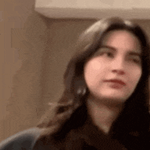 a woman with long hair is making a funny face while looking at the camera .