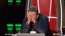 a man sits in a chair with his hands on his face and a nbc logo on the bottom