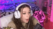 a woman wearing headphones is sitting in a chair in front of a computer .