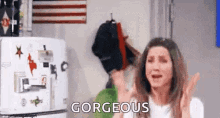 a woman is crying in front of a refrigerator and the word gorgeous is on the wall .