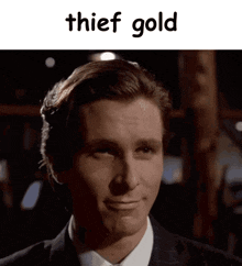 a man in a suit and tie is smiling and the words thief gold are above him