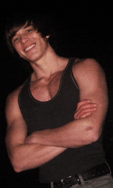 a young man with his arms crossed and a smile on his face