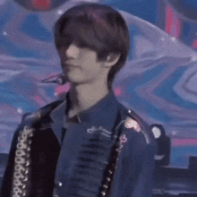 a young man in a blue shirt is standing on a stage .