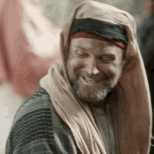 a man with a beard wearing a scarf around his head