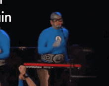 a man in a superhero costume is playing a keyboard on a stage .