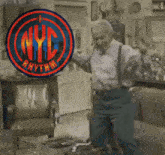 a man is dancing in front of a nyc logo