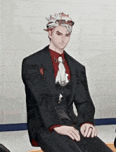 a man wearing a suit and tie is sitting down