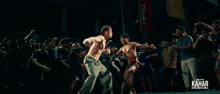 a man is doing a handstand in front of a crowd and the word kahar is on the bottom