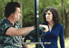 a man and a woman are sitting in a golf cart and the woman is saying so i can surf faster jesse