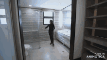 a woman is standing in a bathroom with the words made in animotica on the bottom