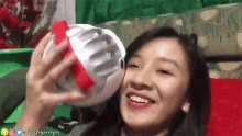 a woman is holding a helmet in her hand and smiling