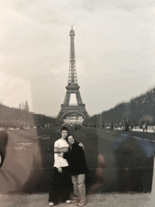 two people pose in front of the eiffel tower in paris