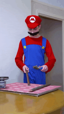 a man dressed as mario holds a hammer