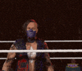 a man wearing a purple mask stands in a wrestling ring with a fnlw logo in the corner