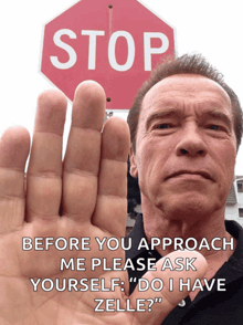 arnold schwarzenegger is holding his hand up in front of a stop sign