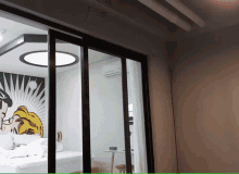 a room with a sliding glass door leading to a bed