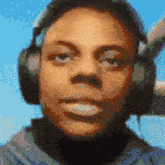a close up of a person wearing headphones with a blue sky in the background