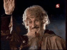 a man with a beard is waving his hand in front of a sign that has the number 5 on it