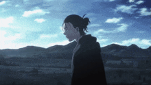 a man with a ponytail is standing in a field