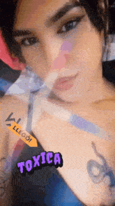 a close up of a woman 's face with the word toxica written on her chest