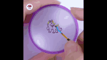 a person is drawing a unicorn on a purple circle with a green brush .
