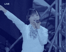 a girl singing into a microphone with the word live on the bottom right