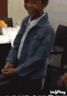 a little girl in a denim jacket stands in front of a table with glasses of wine