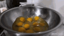eggs are being poured into a metal bowl with the words made in animotica on the bottom