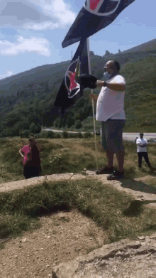 a man in a white shirt is holding a flag with a red star on it