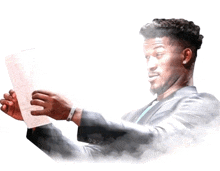 a man in a suit and tie is holding a piece of paper