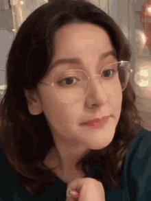 a close up of a woman wearing glasses and making a face