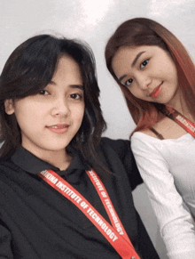 two girls are posing for a picture and one has a lanyard that says institute of technology on it