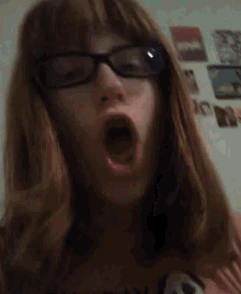 a girl wearing glasses is making a funny face