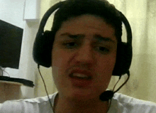 a man wearing headphones and a microphone is making a face