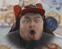 a man wearing a red hat and headphones is making a surprised face .